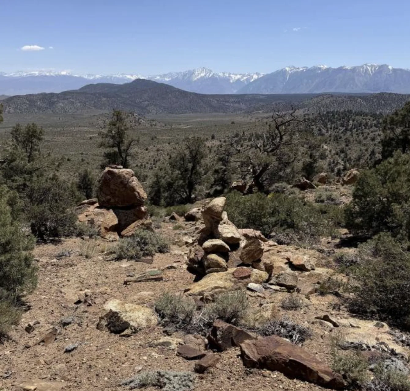 Rock cairn on the ridge with the snow-capped Sierra Nevada crest beyond.