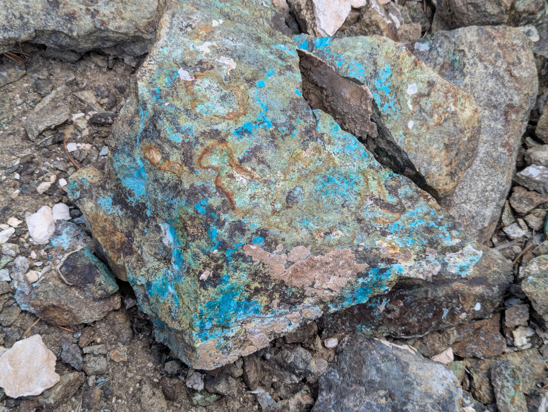 Copper oxides coating a boulder face in the oxidized zone.