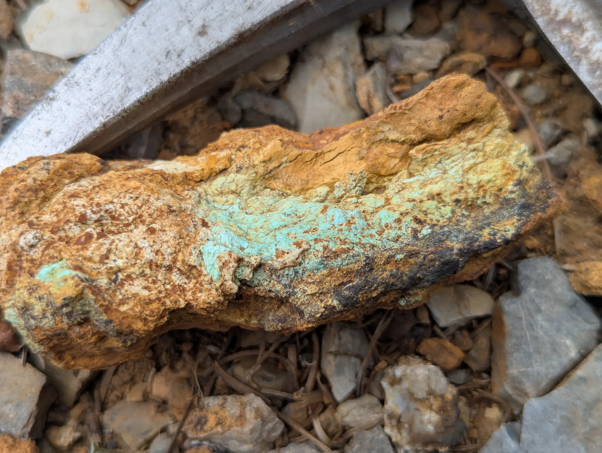 Limonitic gossan carrying a band of green copper oxide.