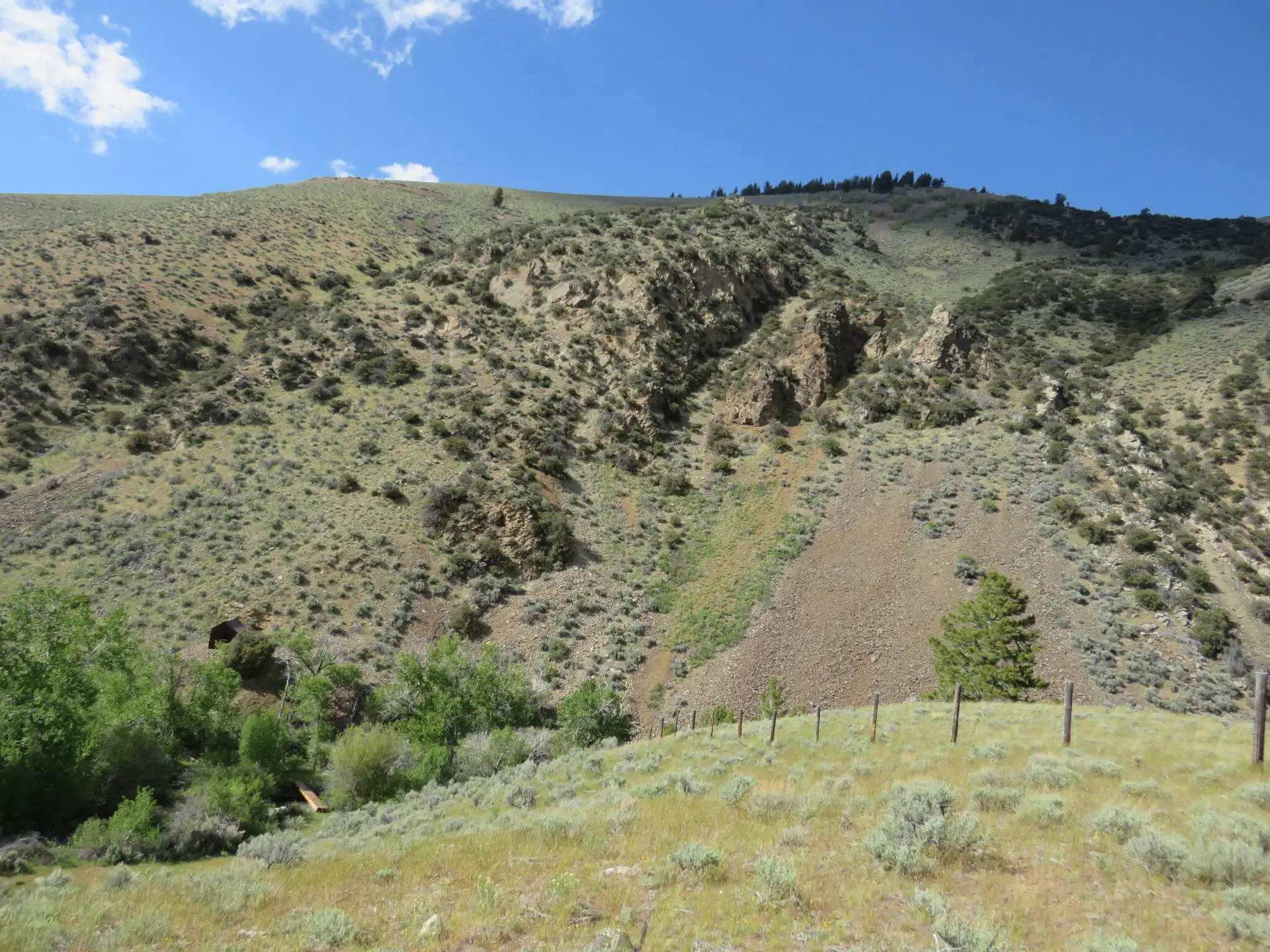 Arid canyon hillside with tailings fan and scrub vegetation Idaho