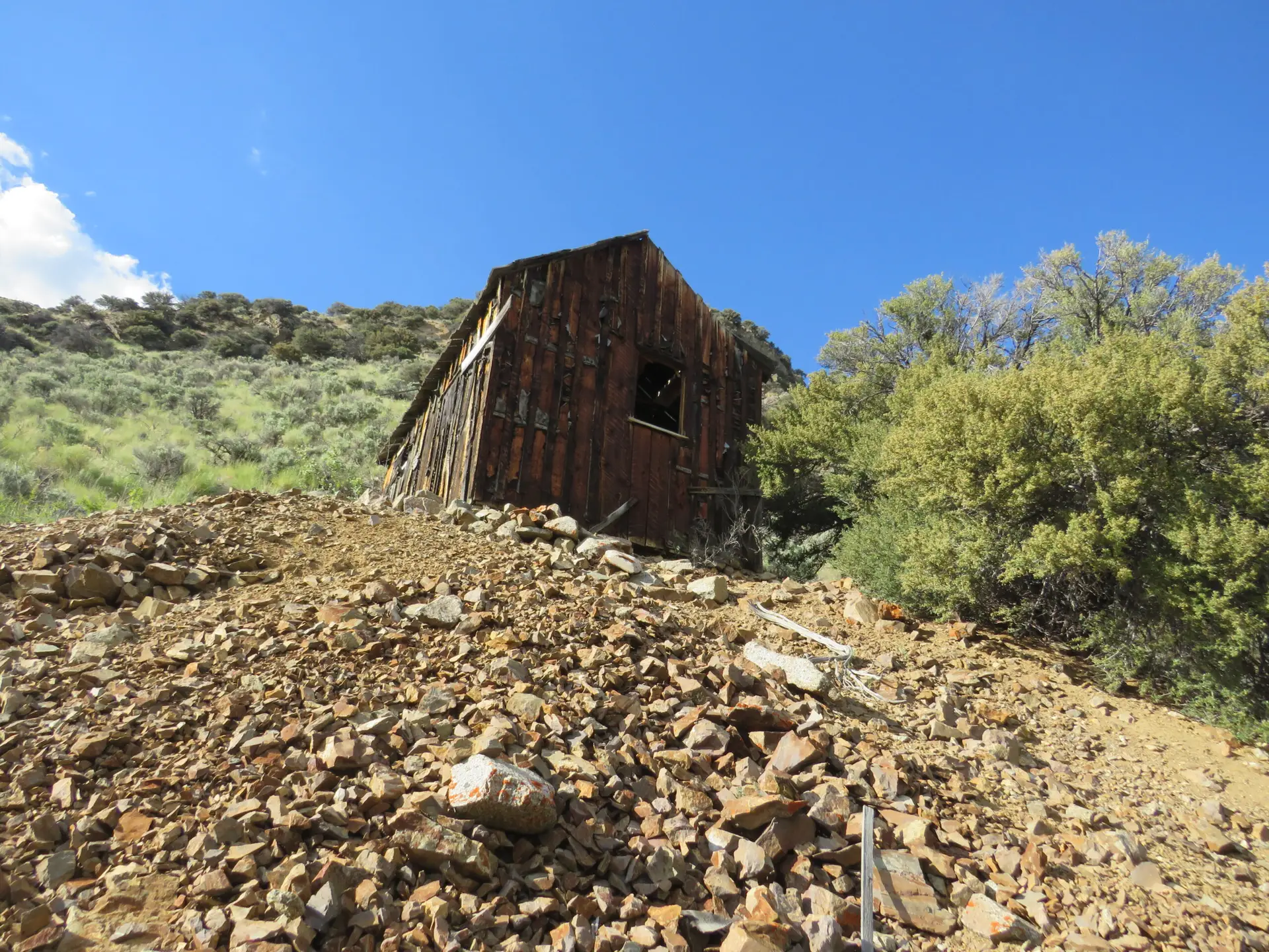 Derelict historic mine building on rocky waste dump Idaho